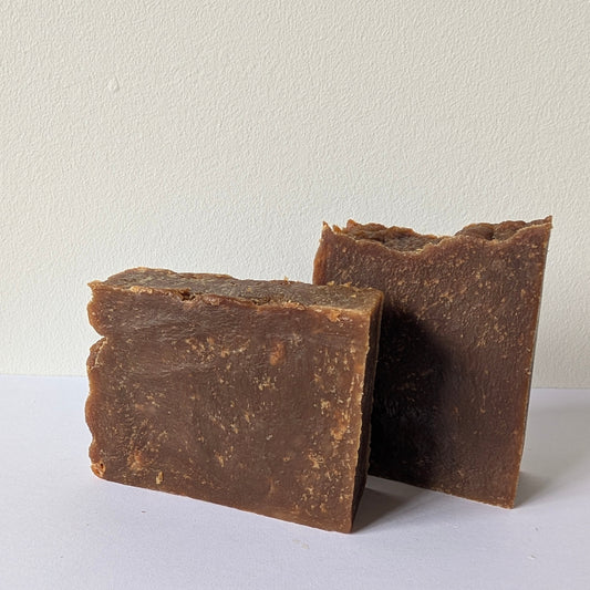 Two pieces of brown soap on a white background