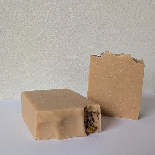 Two brown soap bars on a white surface with a light gray background